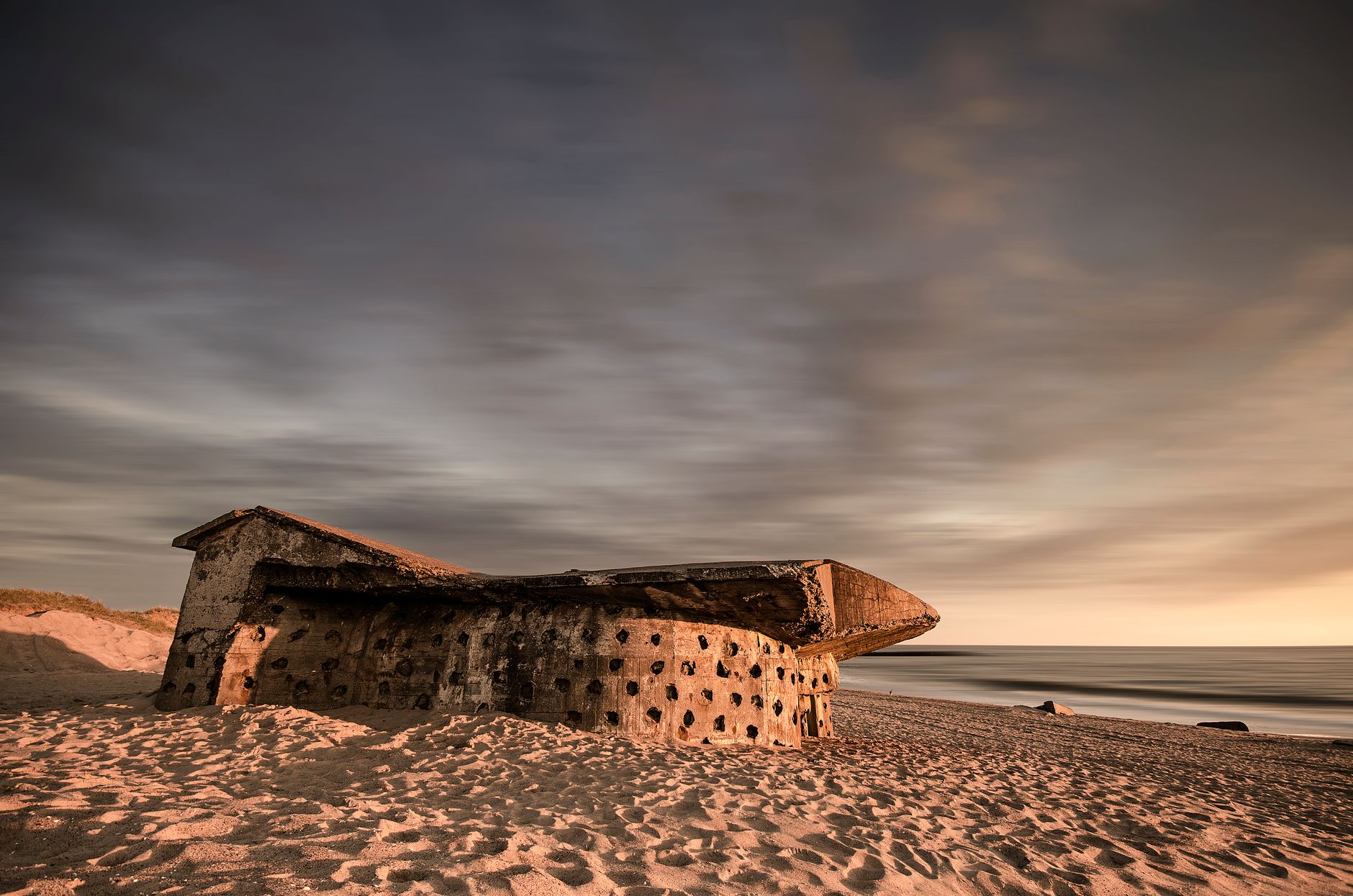 A weathered World War II bunker on Hanstholm beach, Denmark at sunset.