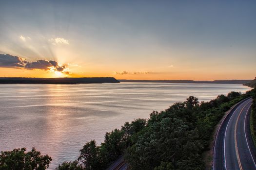 A scenic view of the water and road at sunset