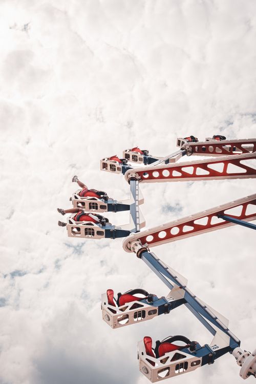 Free Exciting aerial shot of a Ferris wheel ride with people enjoying the high-altitude thrill against a cloudy sky. Stock Photo