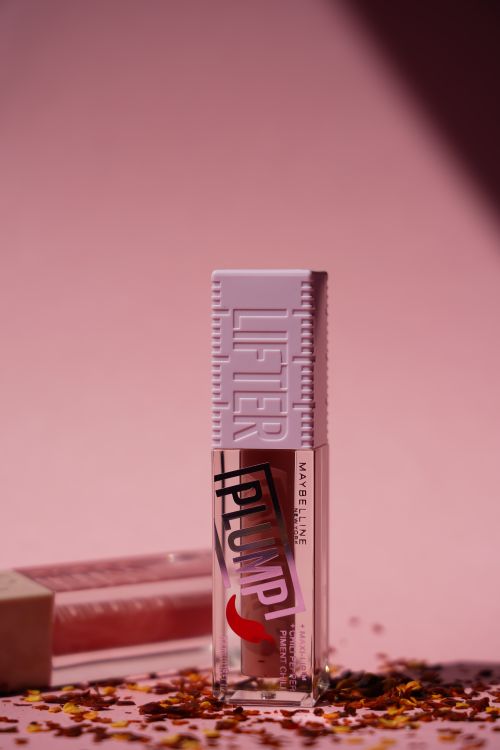 Free Close-up of a lip gloss bottle in a stylish setting, ideal for beauty and fashion themes. Stock Photo