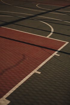 Shadowed lines on an outdoor basketball court in Istanbul, highlighting textures and patterns.