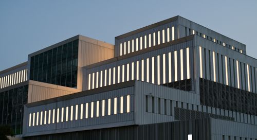 Free A striking contemporary building facade illuminated at dusk, showcasing modern architectural design. Stock Photo