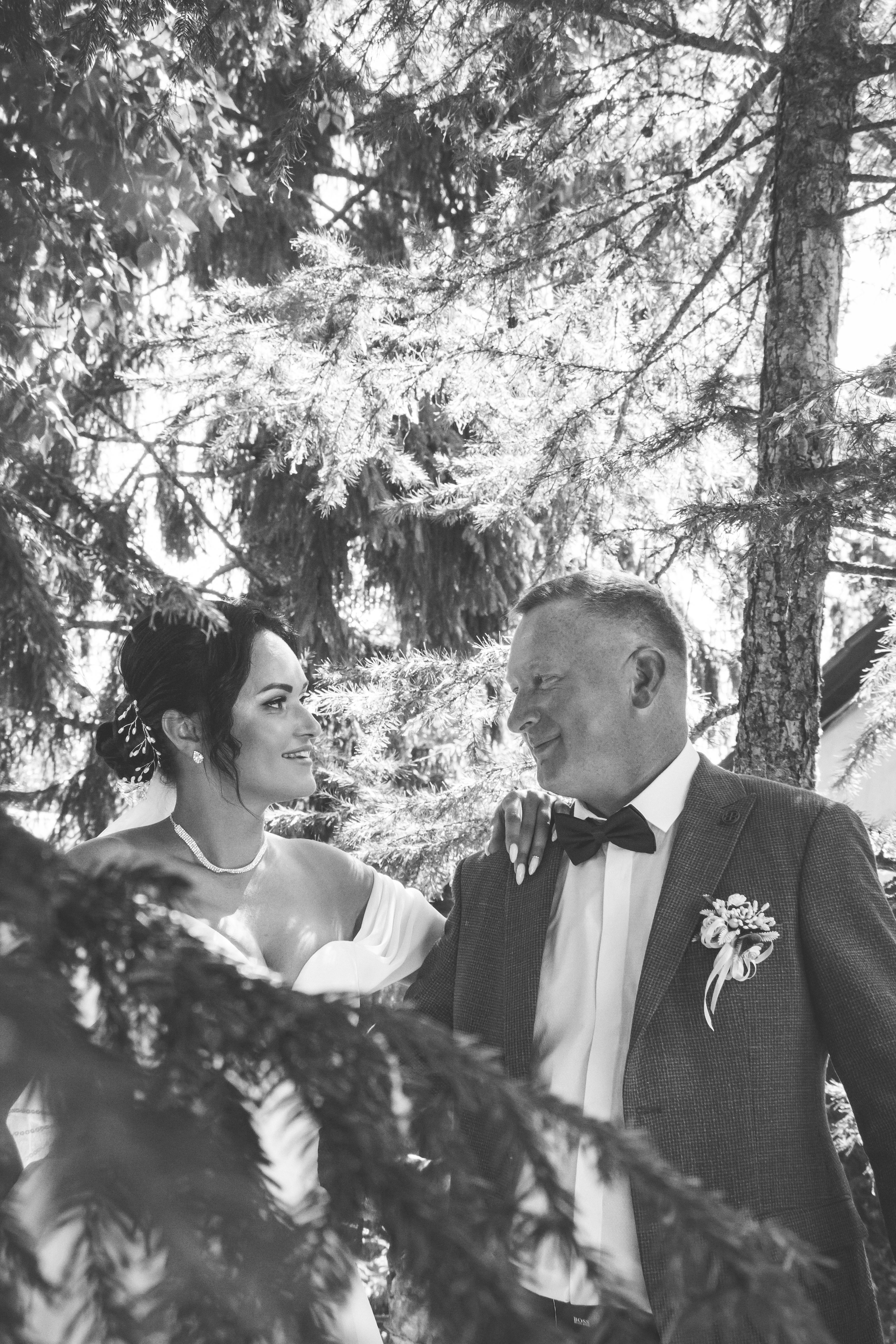 A bride and groom standing in the woods · Free Stock Photo