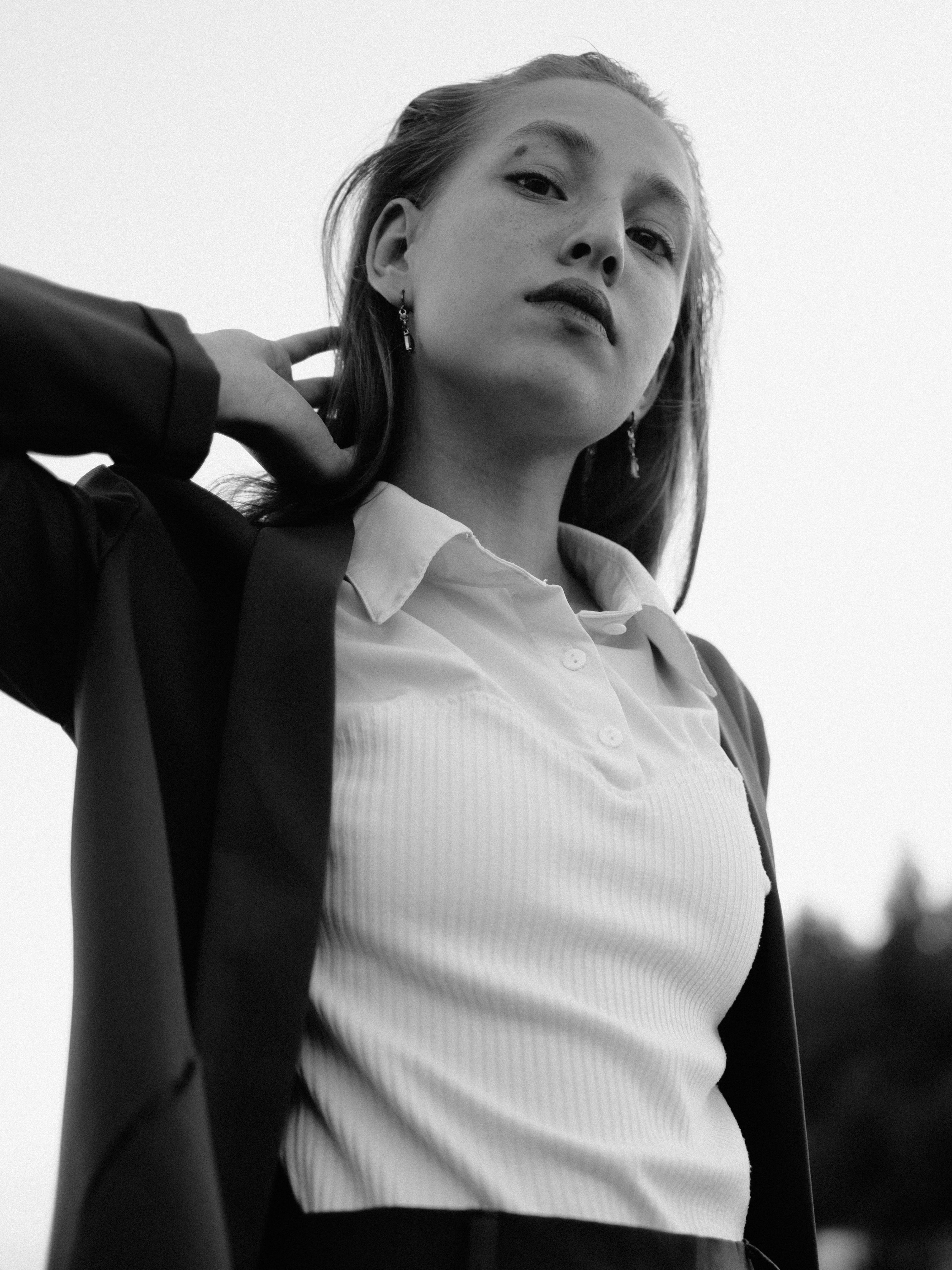 Striking black and white portrait of a confident woman in stylish attire.