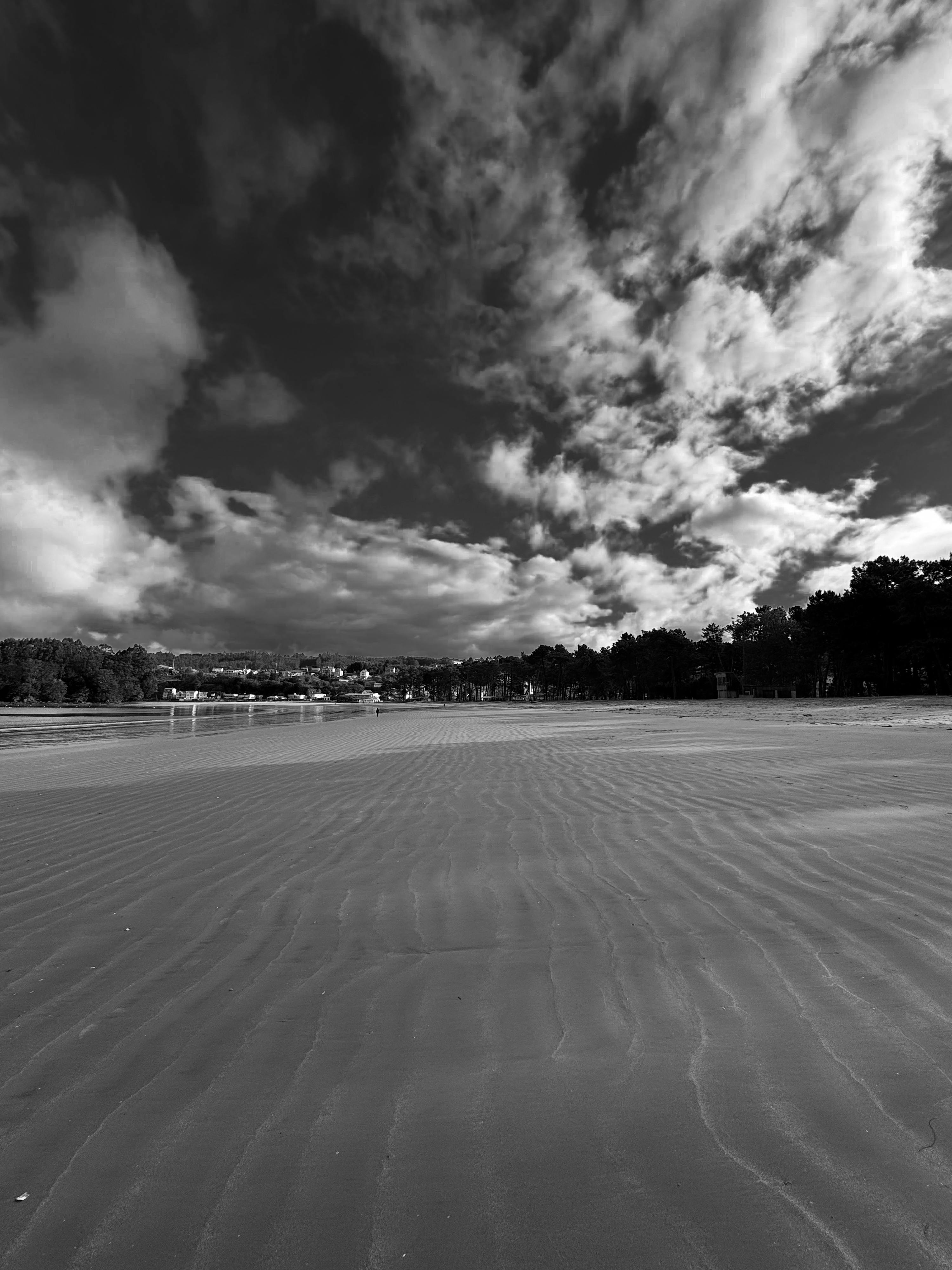 black and white photograph of a beach with clouds