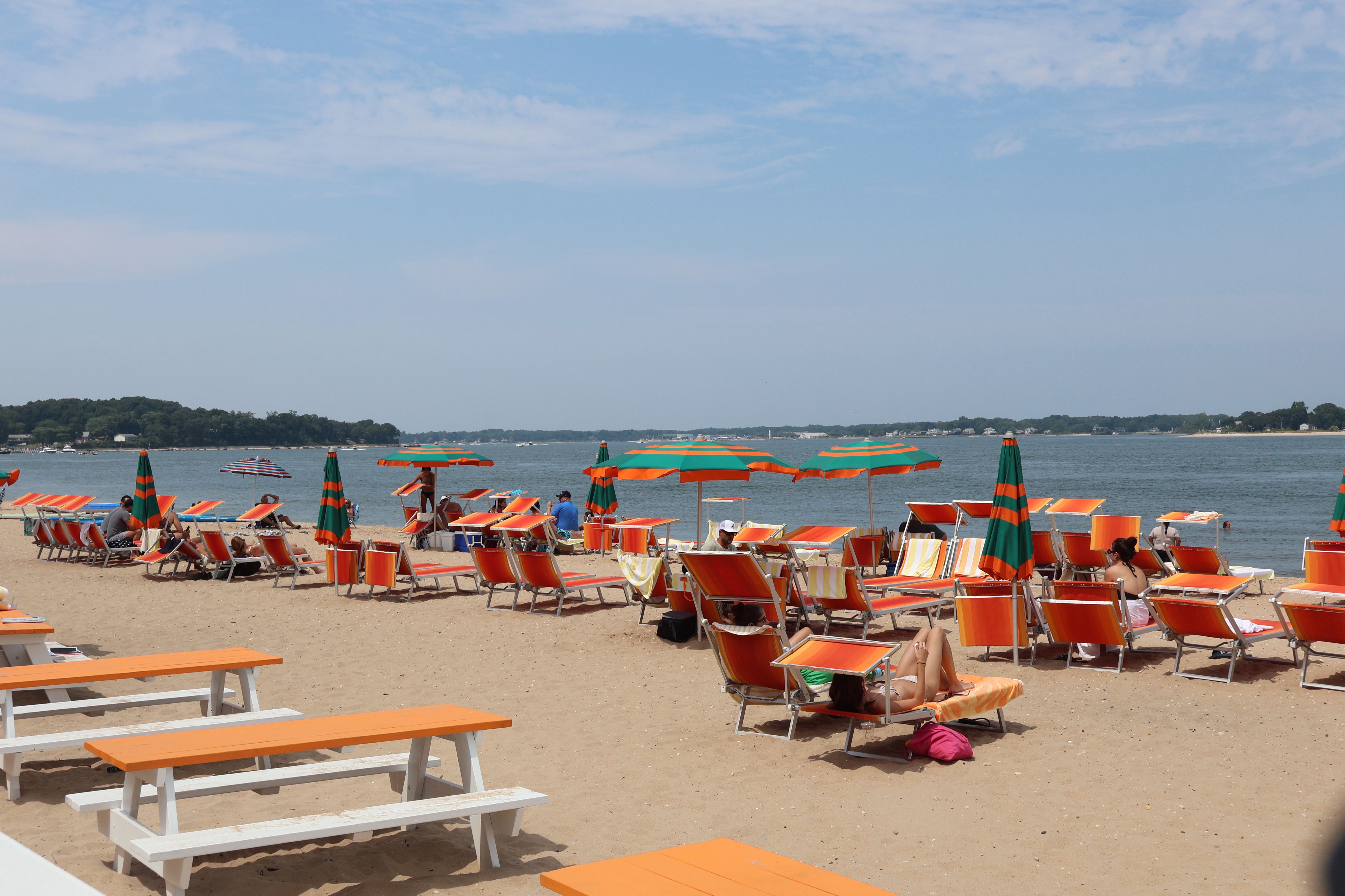 free photo of a beach with orange and white chairs and umbrellas