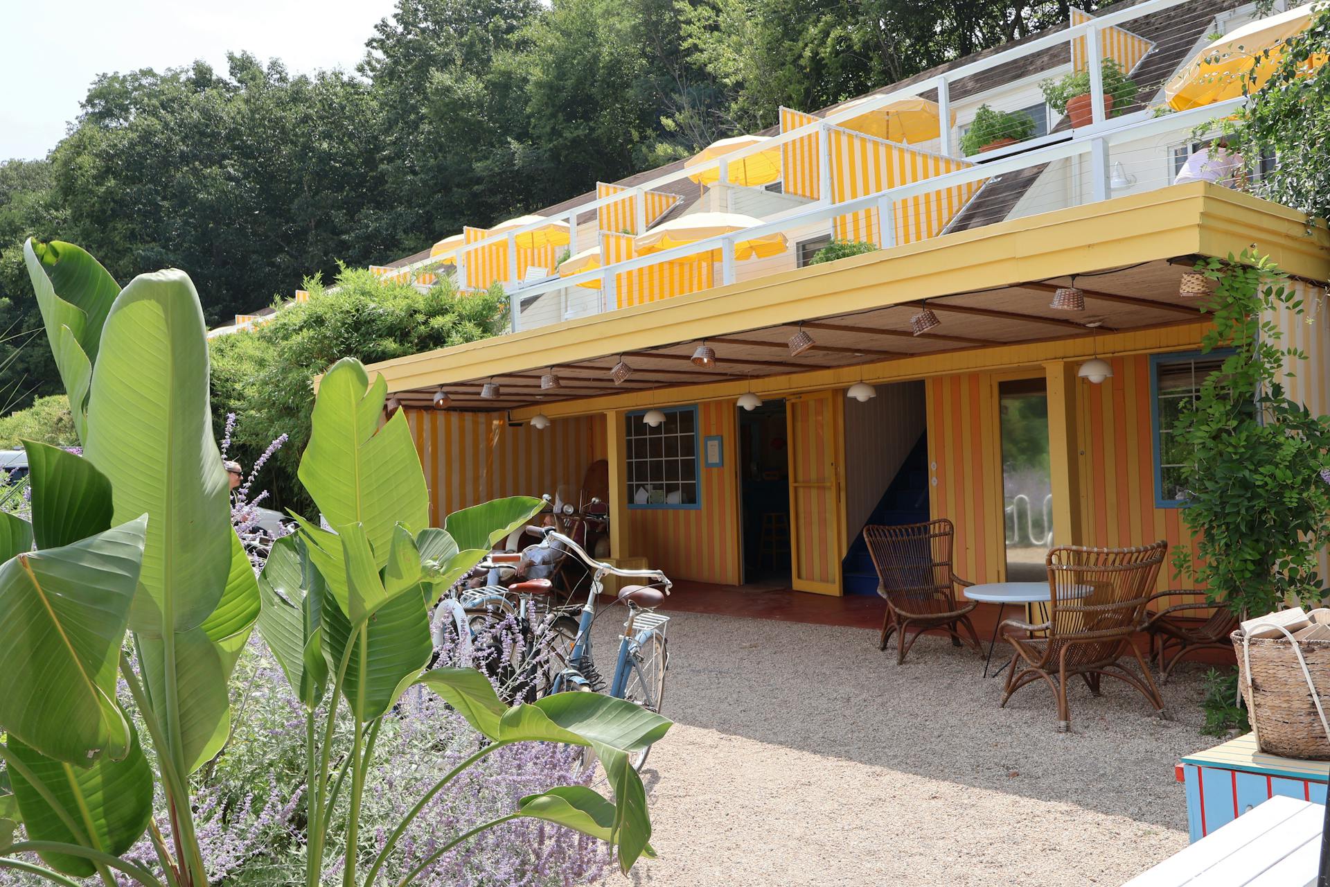 A yellow building with a green roof and a yellow door