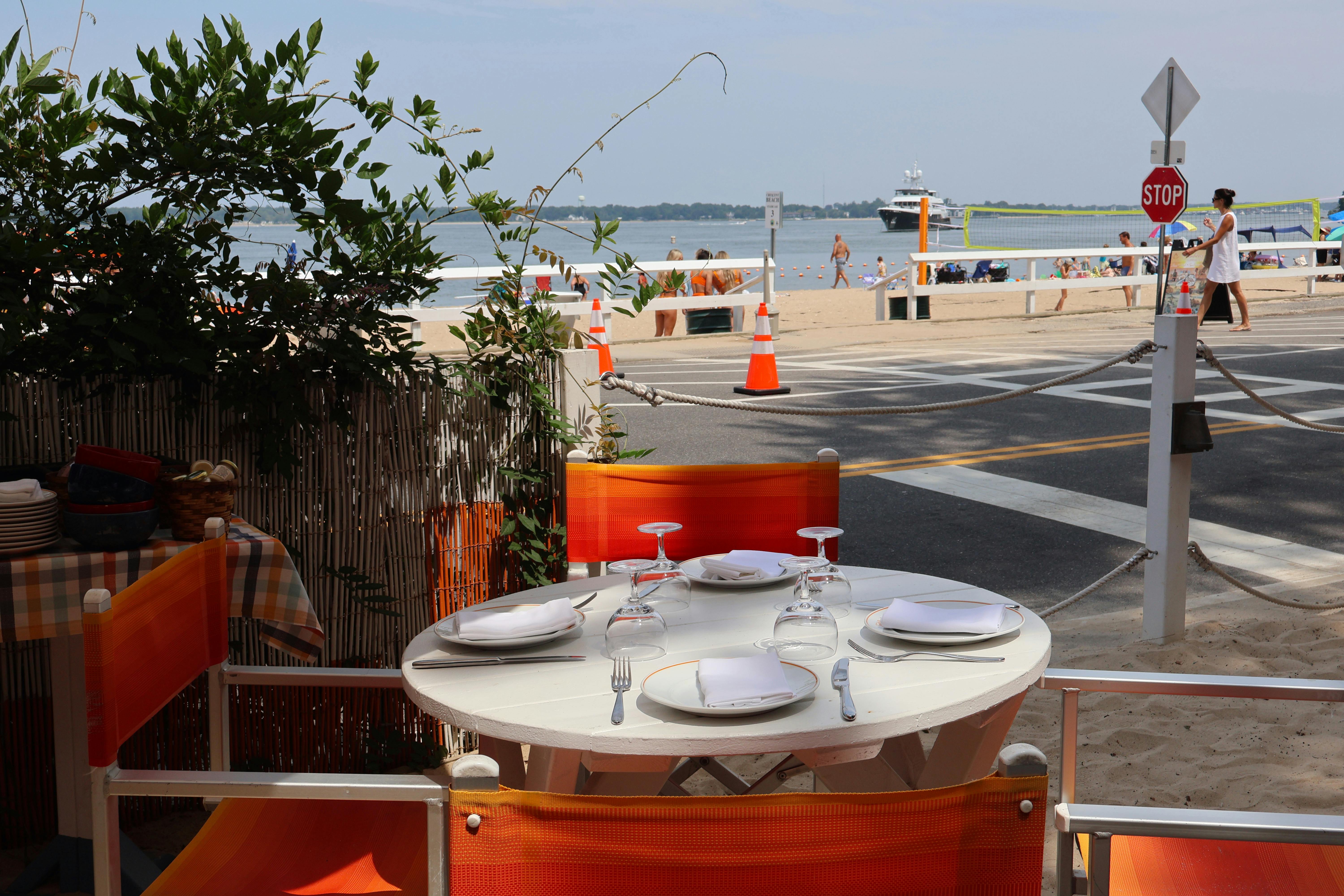 a table with orange chairs and a white tablecloth