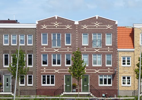 Symmetrical brick residential buildings with intricate geometric facades in a suburban neighborhood.