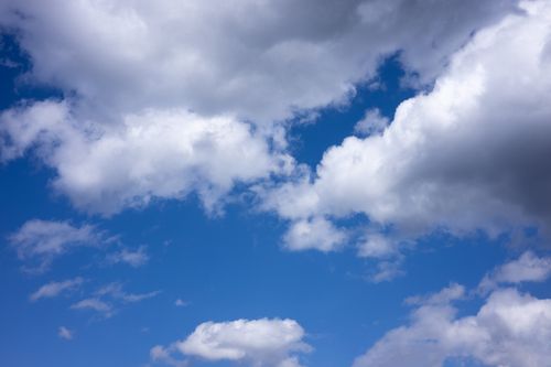 Free Vibrant blue sky filled with fluffy white clouds, perfect for a summer day. Stock Photo