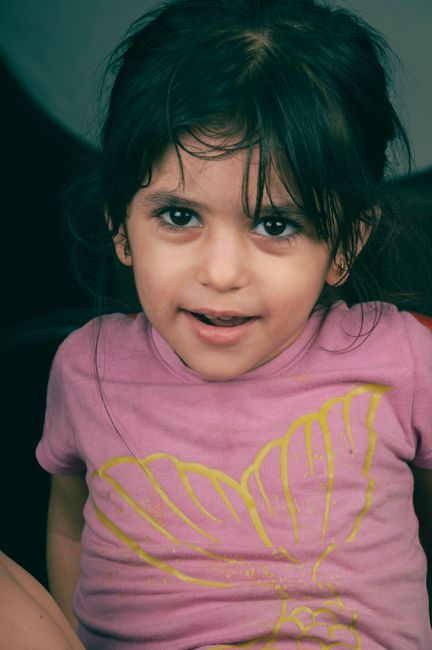 Adorable portrait of a young girl with a warm smile and expressive eyes.