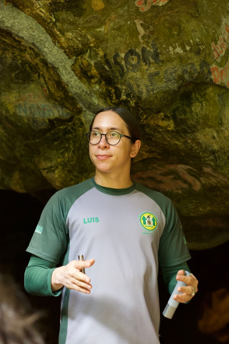 A tour guide stands inside Ubajara Cave, hosting visitors.