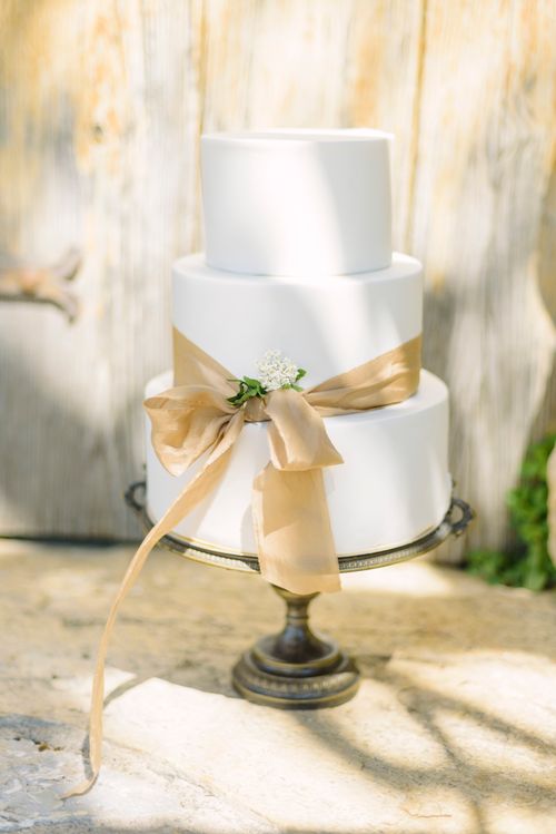 Free A luxurious three-tier wedding cake with floral decor in a rustic setting. Stock Photo