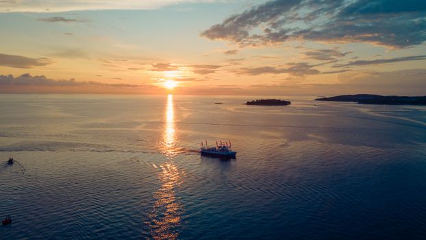 A stunning aerial view of a boat on the Adriatic Sea during sunset near Rovinj, Croatia.