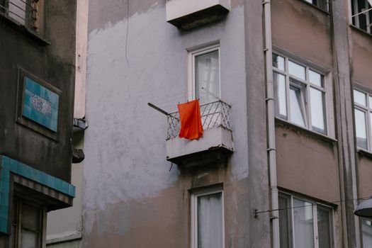 A red flag hanging from a balcony in a city