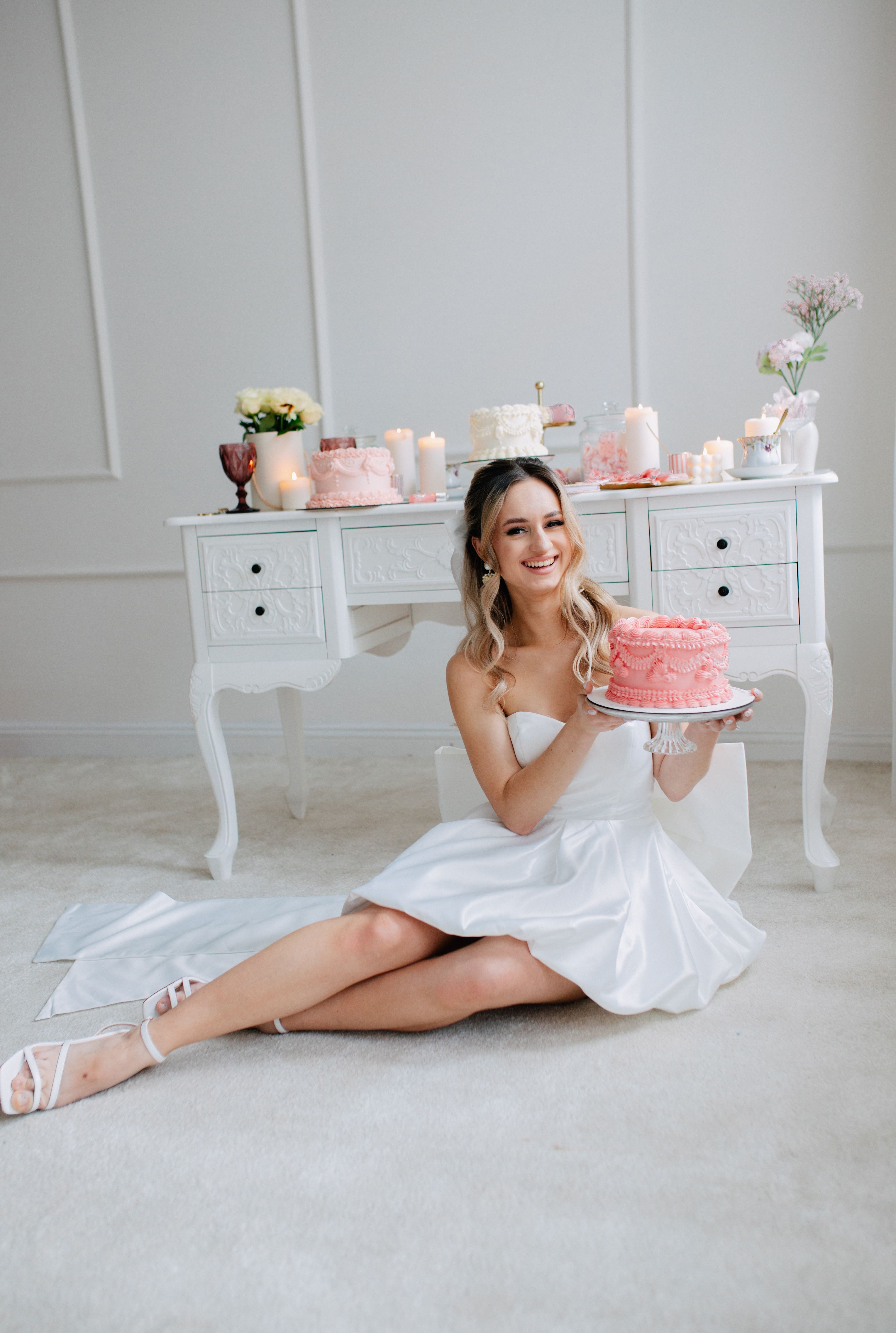 A woman in a white dress sitting on the floor with a cake · Free Stock ...