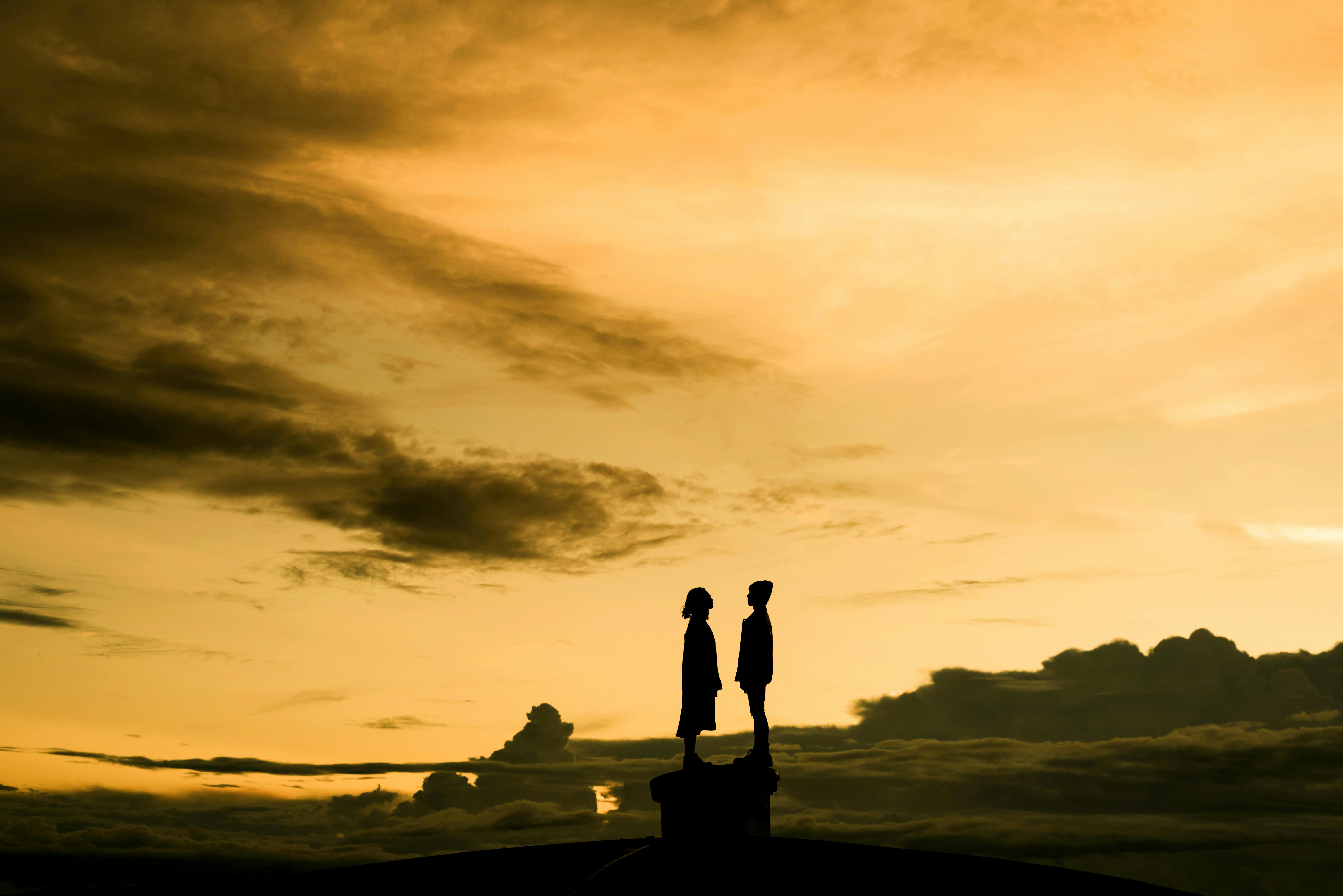 silhouette of people standing on a rock