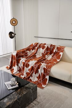 Modern living room featuring a floral patterned throw blanket on a sofa and elegant decor.