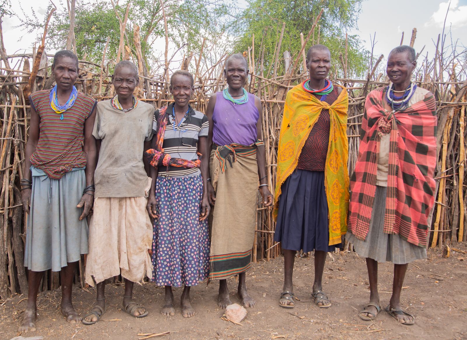 A group of women standing in front of a hut · Free Stock Photo