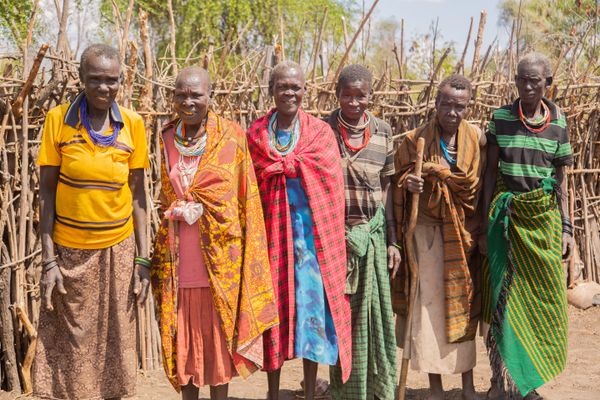 A group of women standing in front of a hut · Free Stock Photo