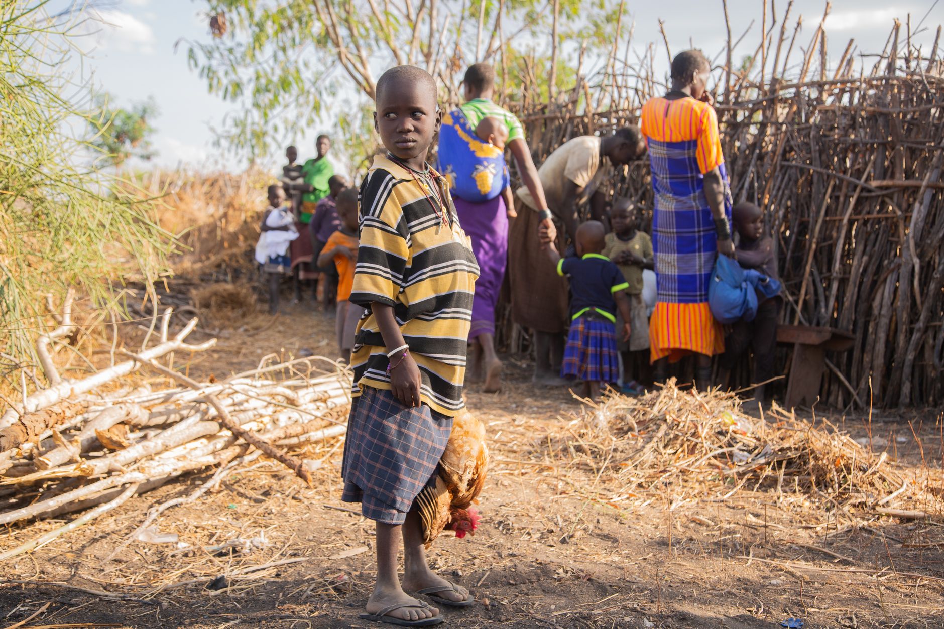 A vibrant scene of daily life in an African village with traditional attire.