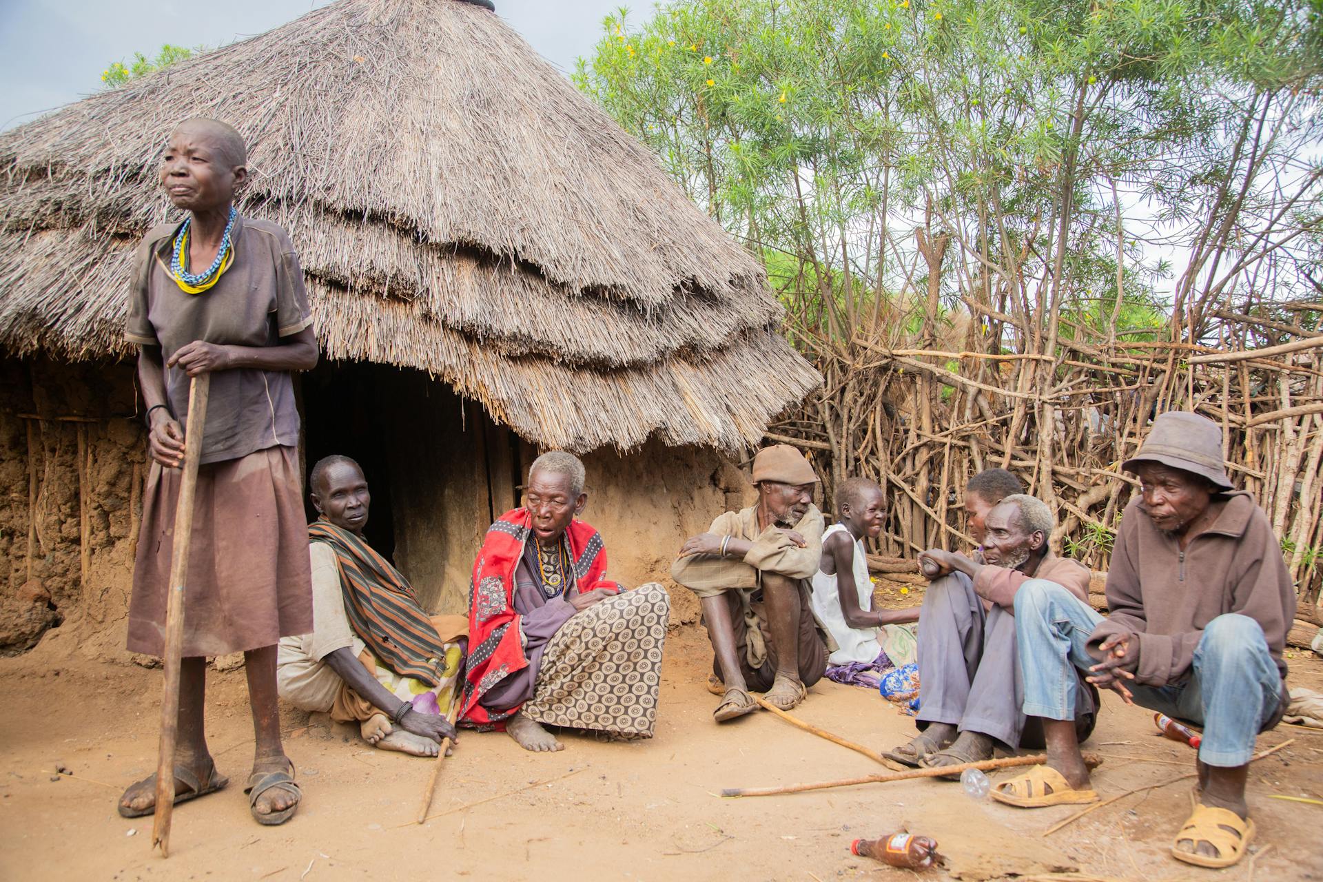 A group of people sitting around a hut