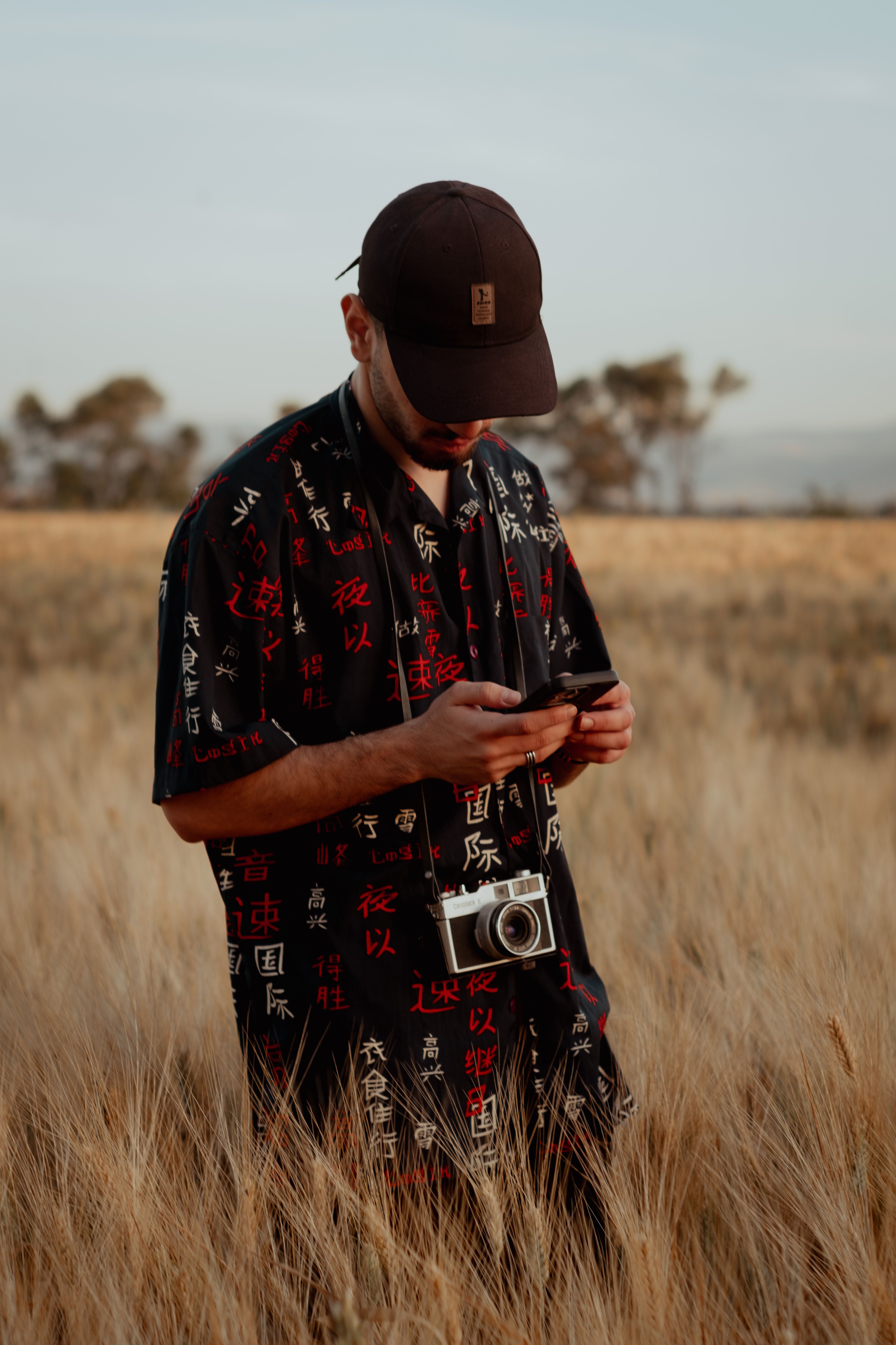 A man in a field looking at his phone · Free Stock Photo