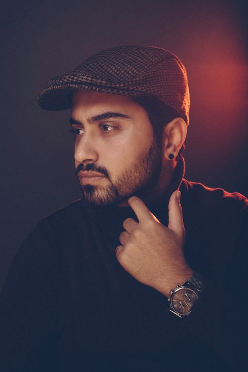 Free Elegant portrait of a stylish man in a flat hat, posing with thoughtful expression. Ideal for fashion photography. Stock Photo