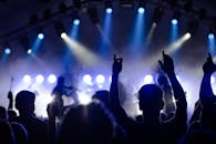 观众在夜间欣赏剪影现场乐队的戏剧性灯光表演