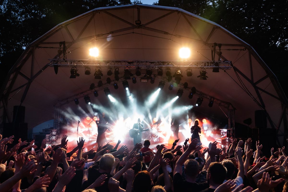 Público disfrutando de un concierto al aire libre con luces ambientales