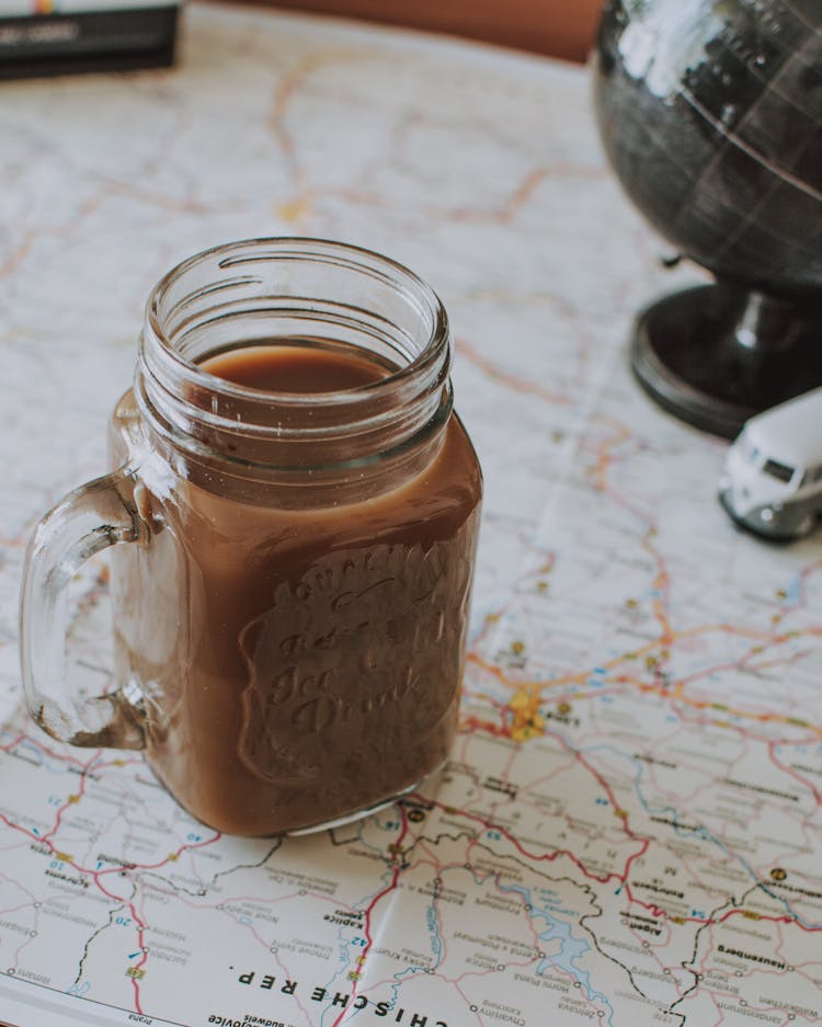 Glass Jar Of Cocoa Drink On Map