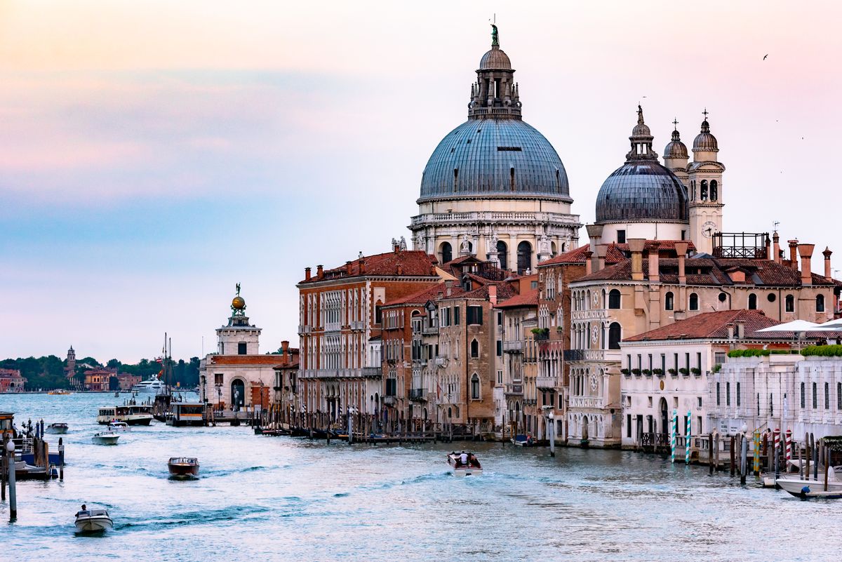 Narrow Venice street with historic stone buildings and arched bridge