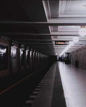 Dark and modern interior view of a Berlin subway station with commuters and empty platform.