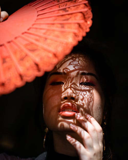 Woman Covering Her Face With Orange Umbrella