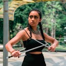 在户外背景下，一名女子自信地摆出武术姿势，展现出美丽与力量