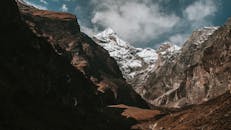 在充满活力的蓝天下，雪山景观令人惊叹，云层壮观