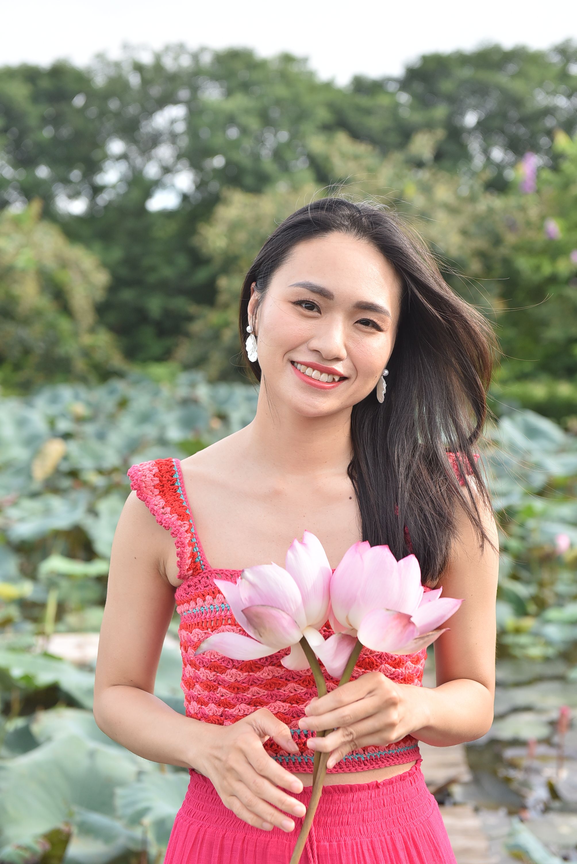 A woman in pink holding a bunch of flowers · Free Stock Photo