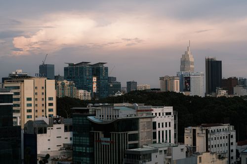 Free A cityscape with skyscrapers and a warm sunset sky, showcasing urban architecture. Stock Photo