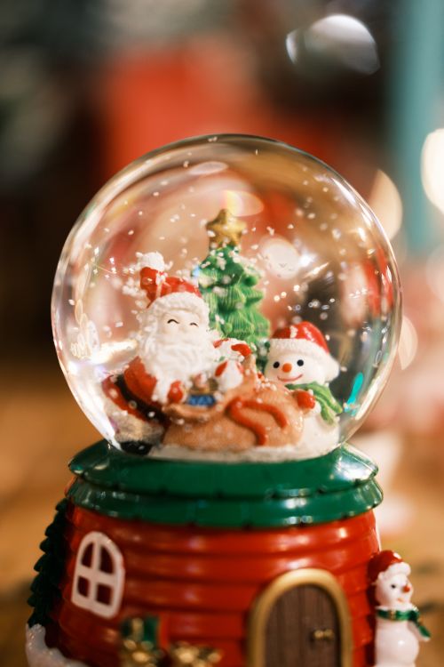 Free Snow globe featuring Santa, snowman, and Christmas tree for holiday celebration. Stock Photo