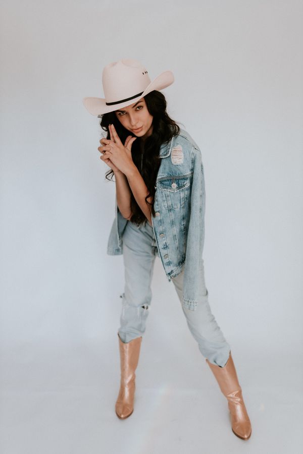 woman in white henley top and jeans with western boots