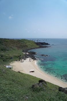A stunning seaside view of a tropical beach in Phan Thiết, Vietnam, featuring clear blue waters and lush greenery.