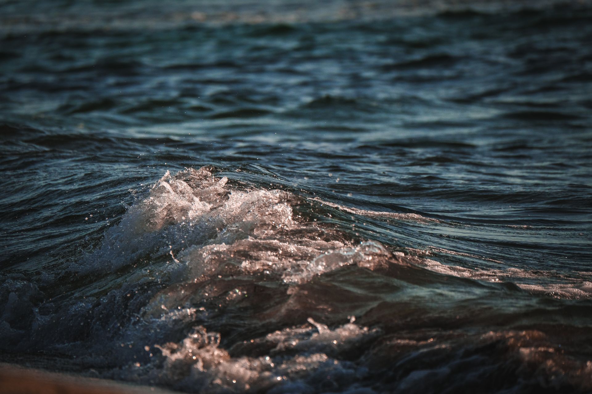 A close up of the ocean waves crashing on the beach