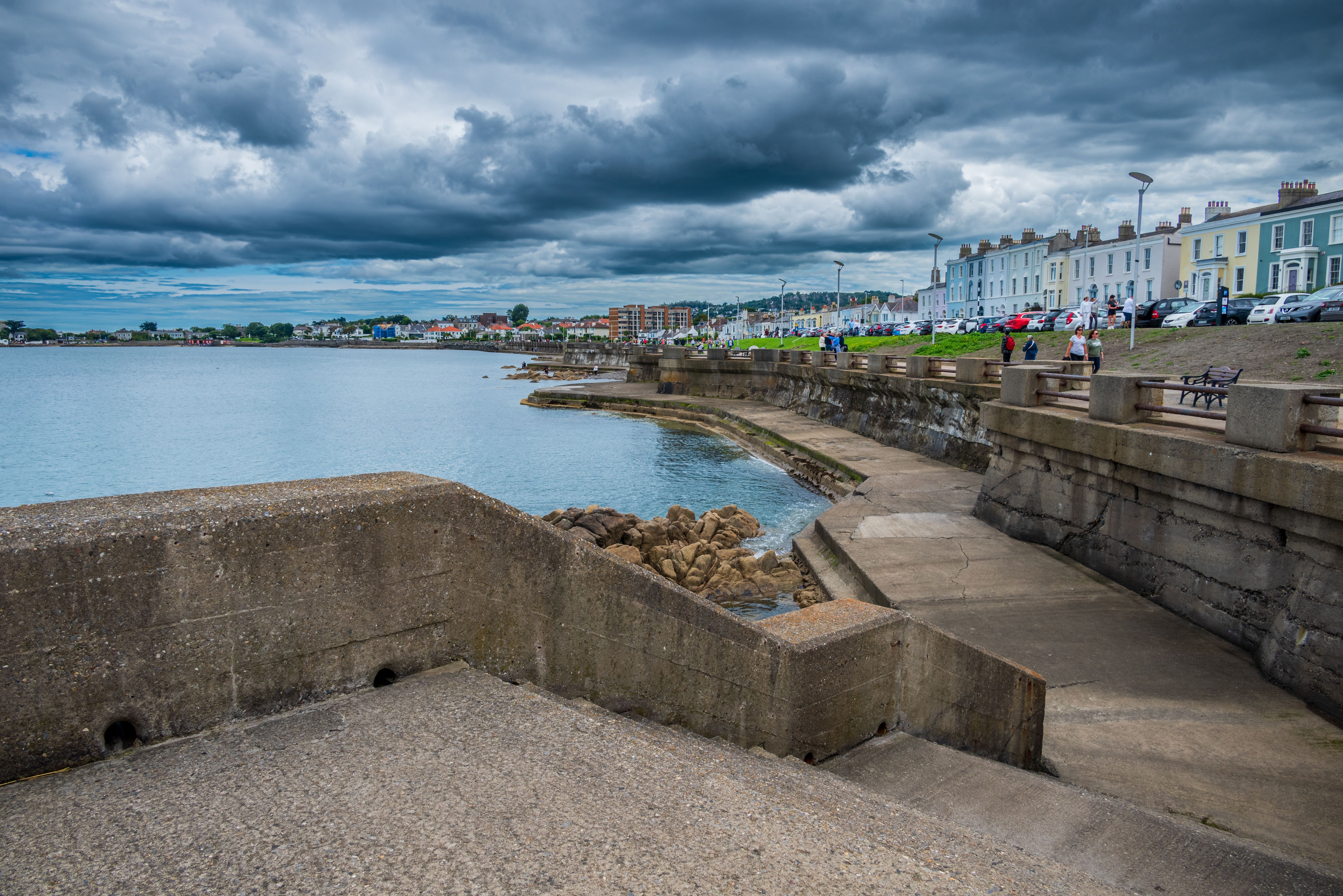 A view of the ocean and a pier under cloudy skies · Free Stock Photo