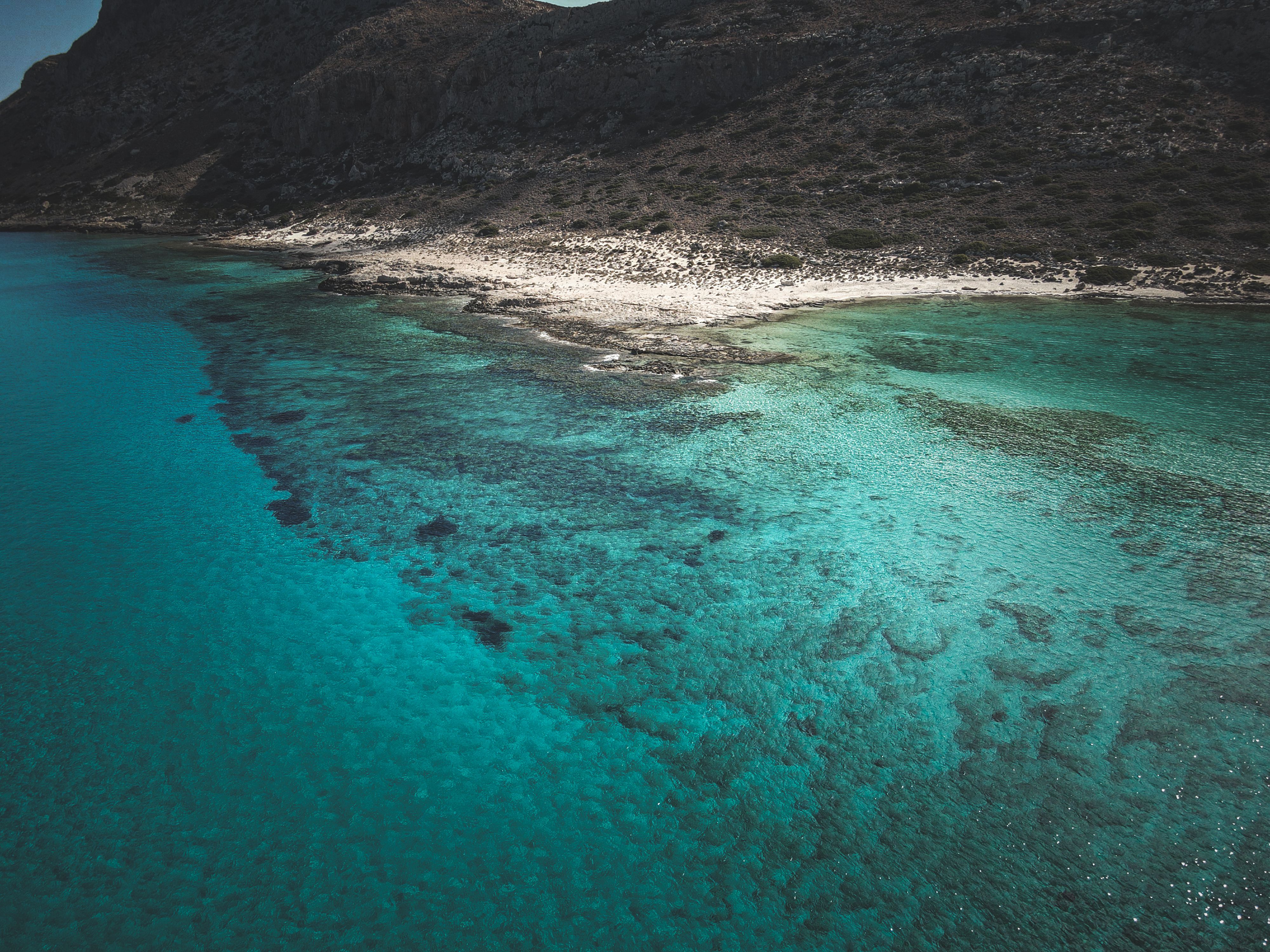 An aerial view of a beach with blue water · Free Stock Photo