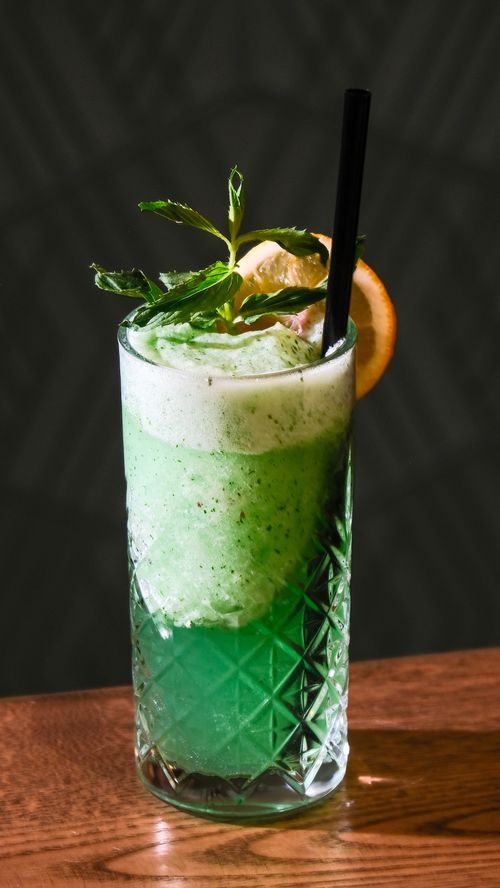 Free Green mint and citrus cocktail in a crystal glass with lime and mint garnish, perfect for summer refreshment. Stock Photo
