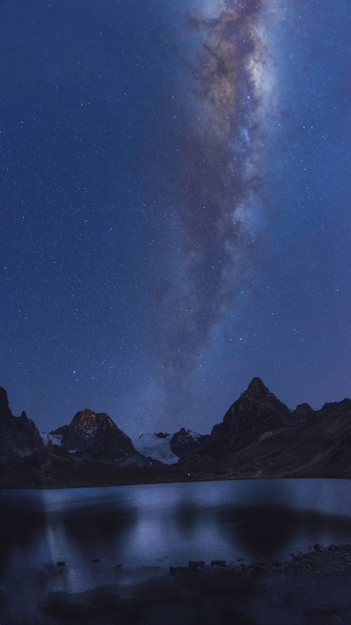 Free Capture of the Milky Way over a tranquil mountain lake under a starry night sky, showcasing nature's beauty. Stock Photo