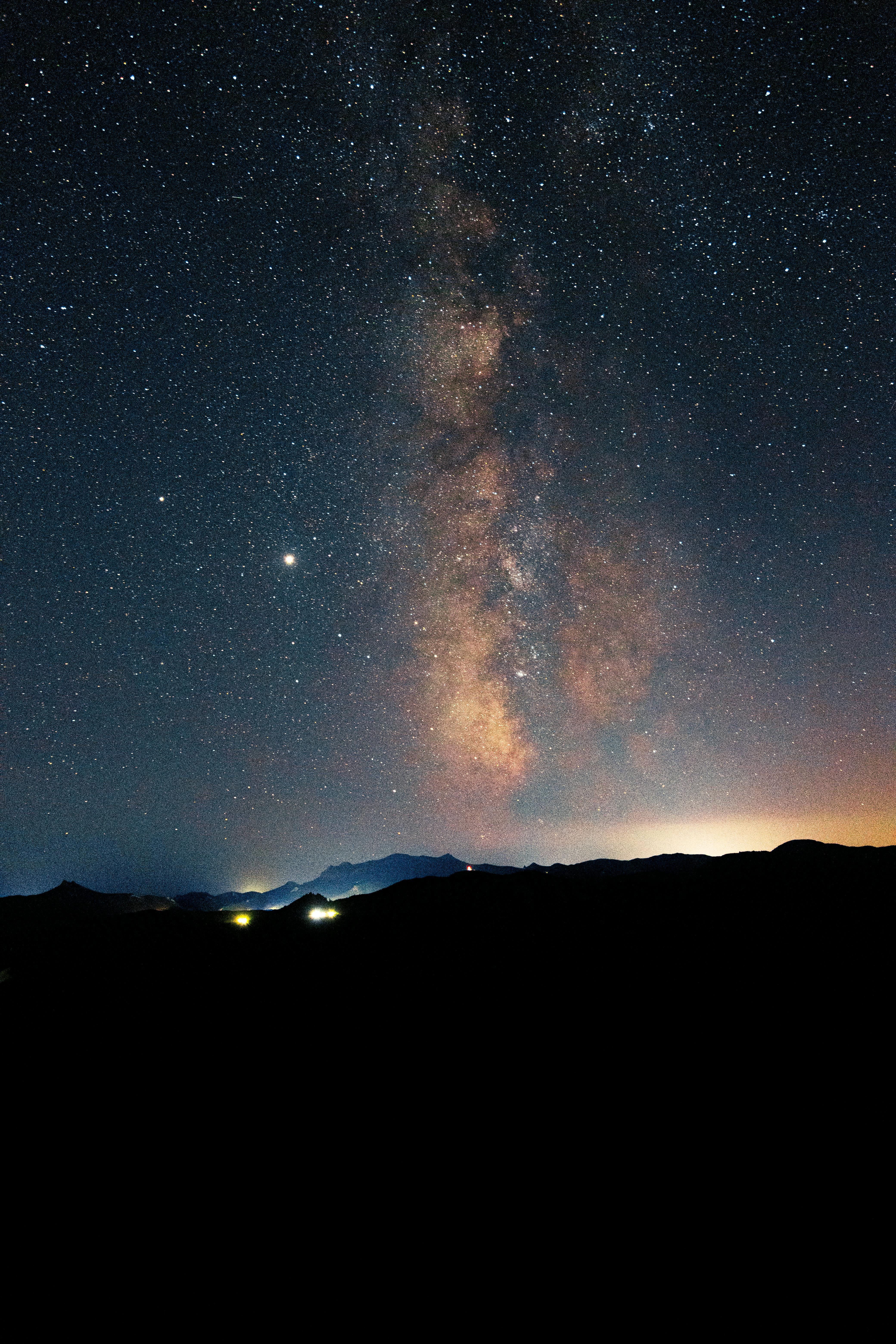 Mesmerizing view of the Milky Way galaxy illuminating the night sky over a silhouetted mountain range.