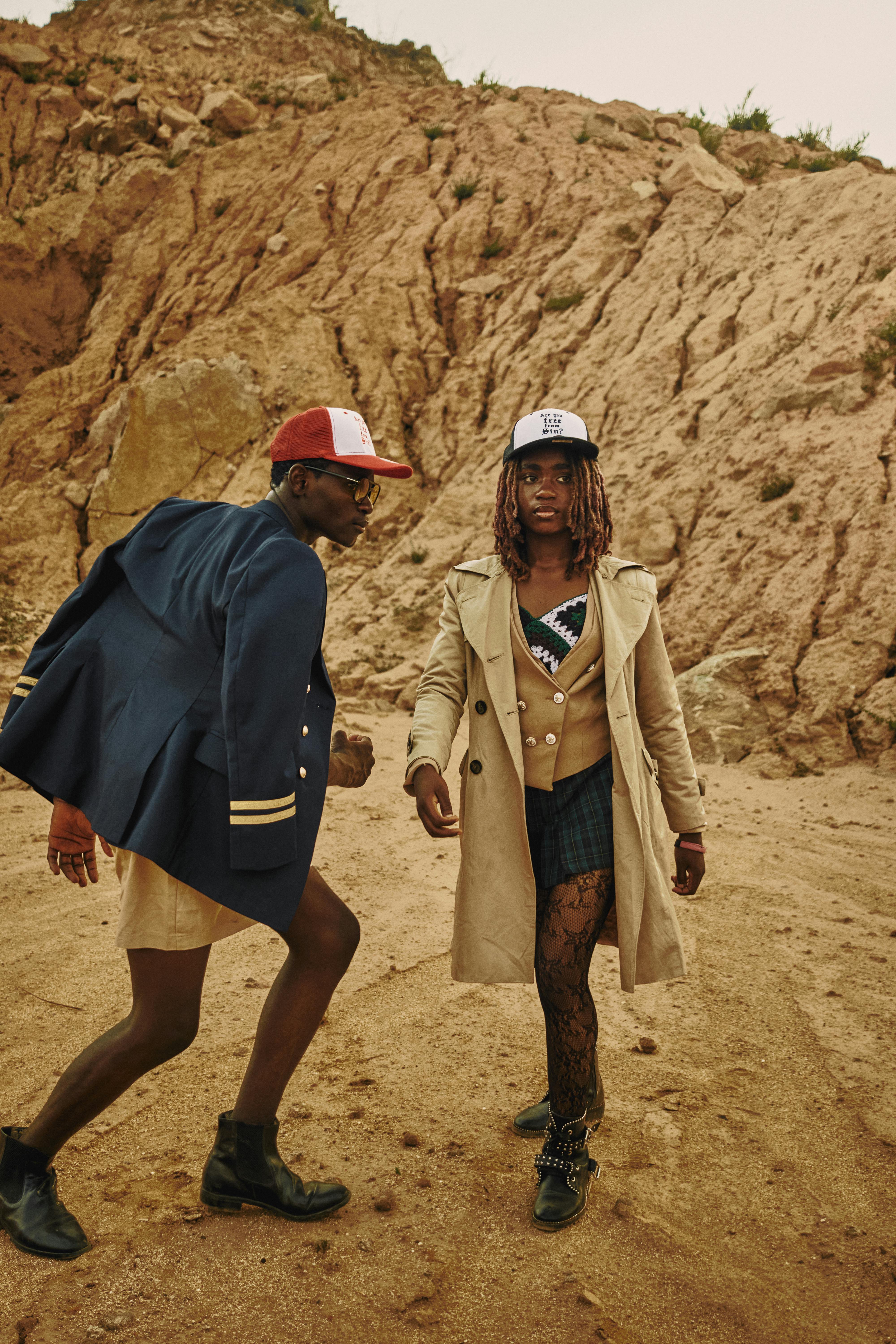 woman and man in caps and coats on desert