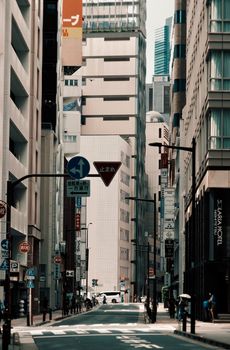 A bustling urban street in downtown Tokyo with modern architecture and vibrant signage.