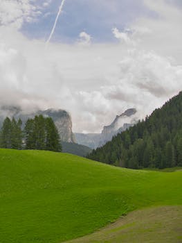 Breathtaking landscape of Val Gardena in Trentino-Alto Adige, Italy with lush green meadows and misty mountains.